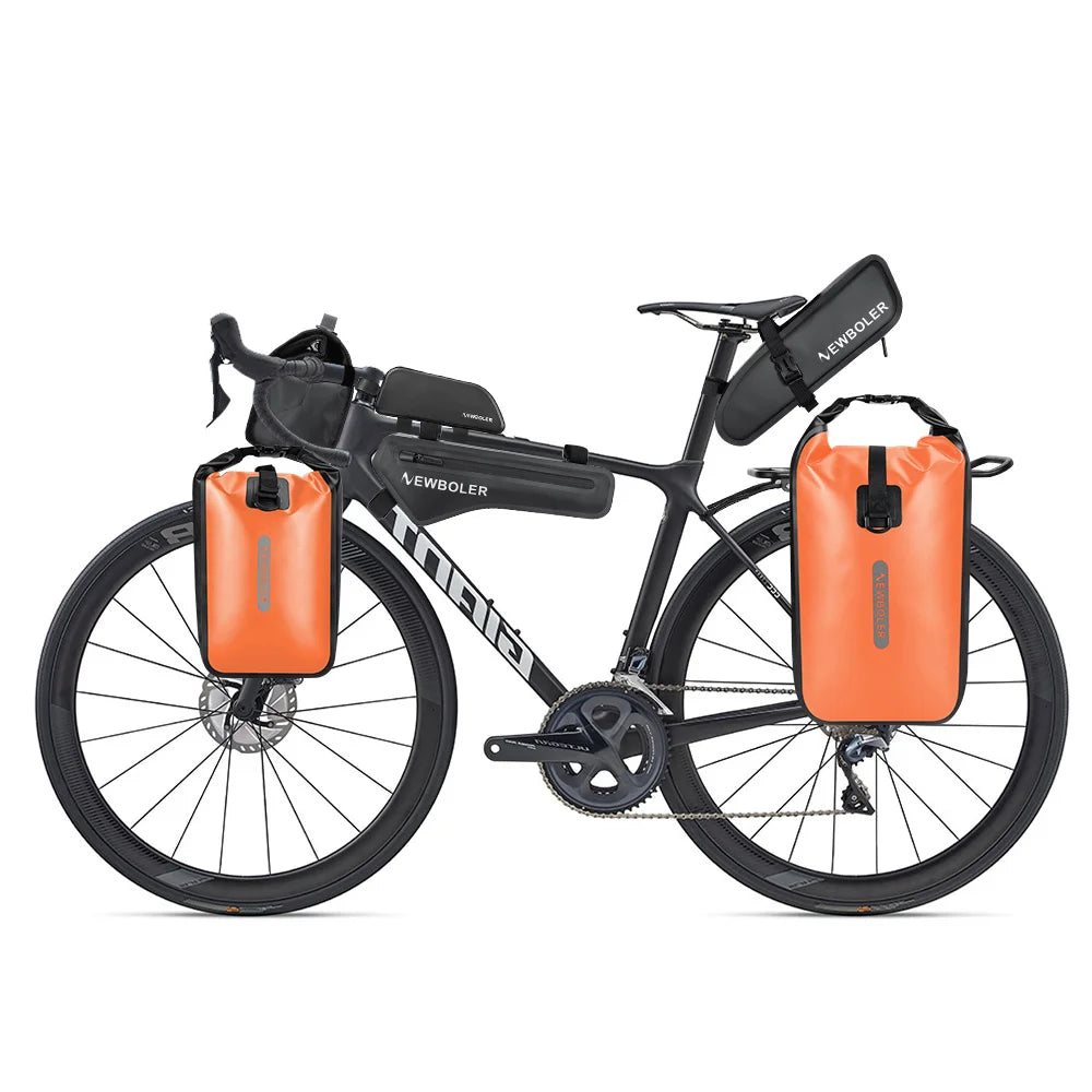 Vélo gravel équipé de sacoches de fourche, d'une sacoche de cadre, d'une sacoche de selle et de deux sacoches arrière orange