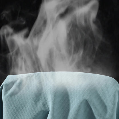 Démonstration respirabilité — vapeur s'échappant du tissu Light Green en gros plan, fond noir