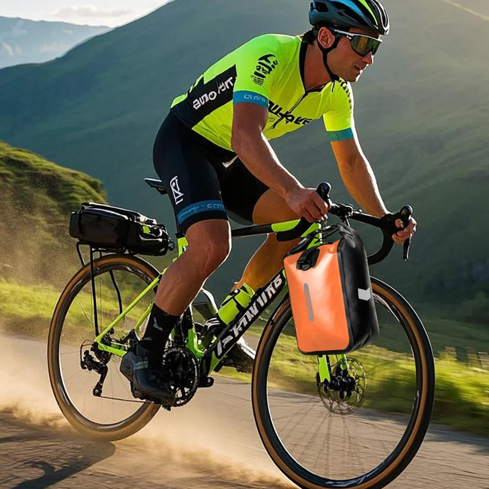 Cycliste en tenue verte roulant en montagne, une sacoche orange montée près du cintre