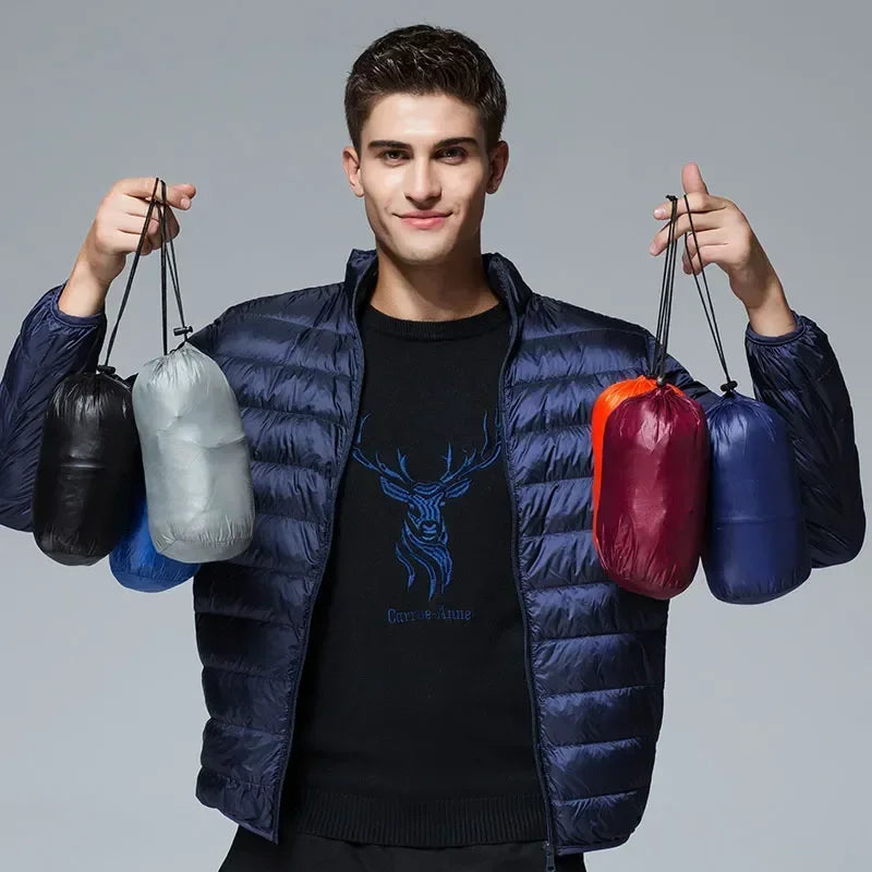 Homme portant la doudoune bleu marine, tenant dans chaque main deux pochettes de rangement assorties à d'autres coloris