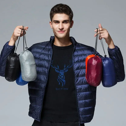 Homme portant la doudoune bleu marine, tenant dans chaque main deux pochettes de rangement assorties à d'autres coloris