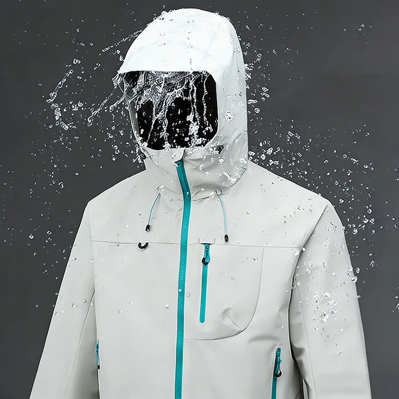 Test imperméabilité veste blanc/crème sous jet d'eau — zips bleu turquoise, capuche, fond gris studio