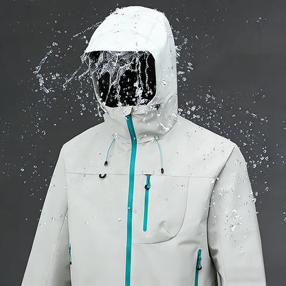 Test imperméabilité veste blanc/crème sous jet d'eau — zips bleu turquoise, capuche, fond gris studio