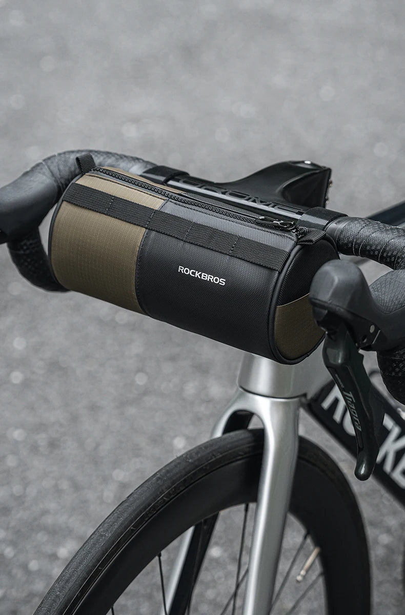 Sacoche de guidon ROCKBROS 1,7L kaki/noir montée sur cintre de vélo de route — vue lifestyle face avant, zip sur le dessus et logo réfléchissant visibles