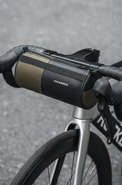 Sacoche de guidon ROCKBROS 1,7L kaki/noir montée sur cintre de vélo de route — vue lifestyle face avant, zip sur le dessus et logo réfléchissant visibles