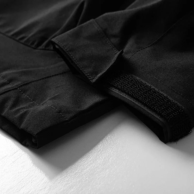 Macro manchette velcro veste noire — réglage poignet ouvert, doublure intérieure visible