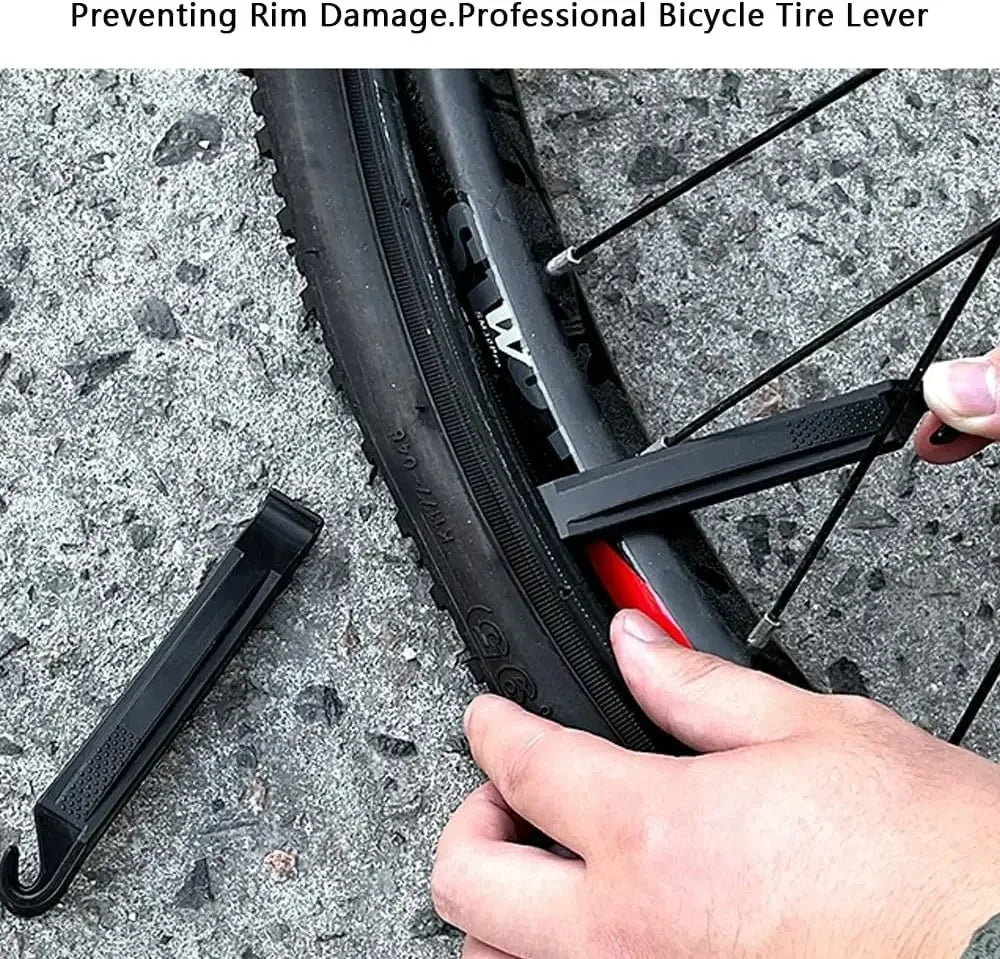 'Preventing Rim Damage — Professional Bicycle Tire Lever' : levier noir sous le flanc d'un pneu, jante rouge visible, fond asphalte