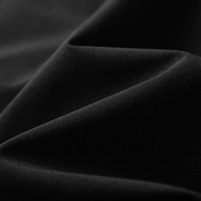 Macro tissu drapé veste noire — texture doublure souple, tombé du tissu intérieur