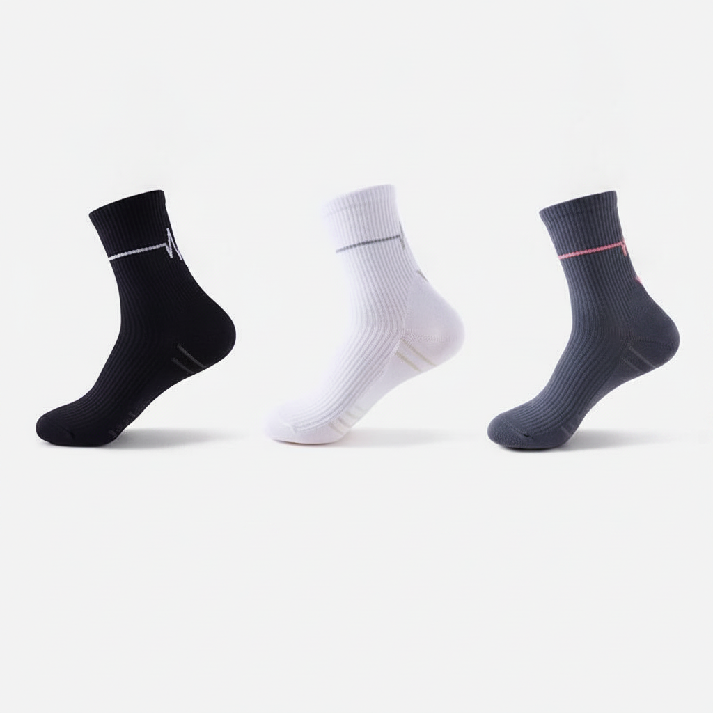 Studio : trois chaussettes de coloris différents (noir, blanc, gris foncé) alignées côte à côte, lot Mix B